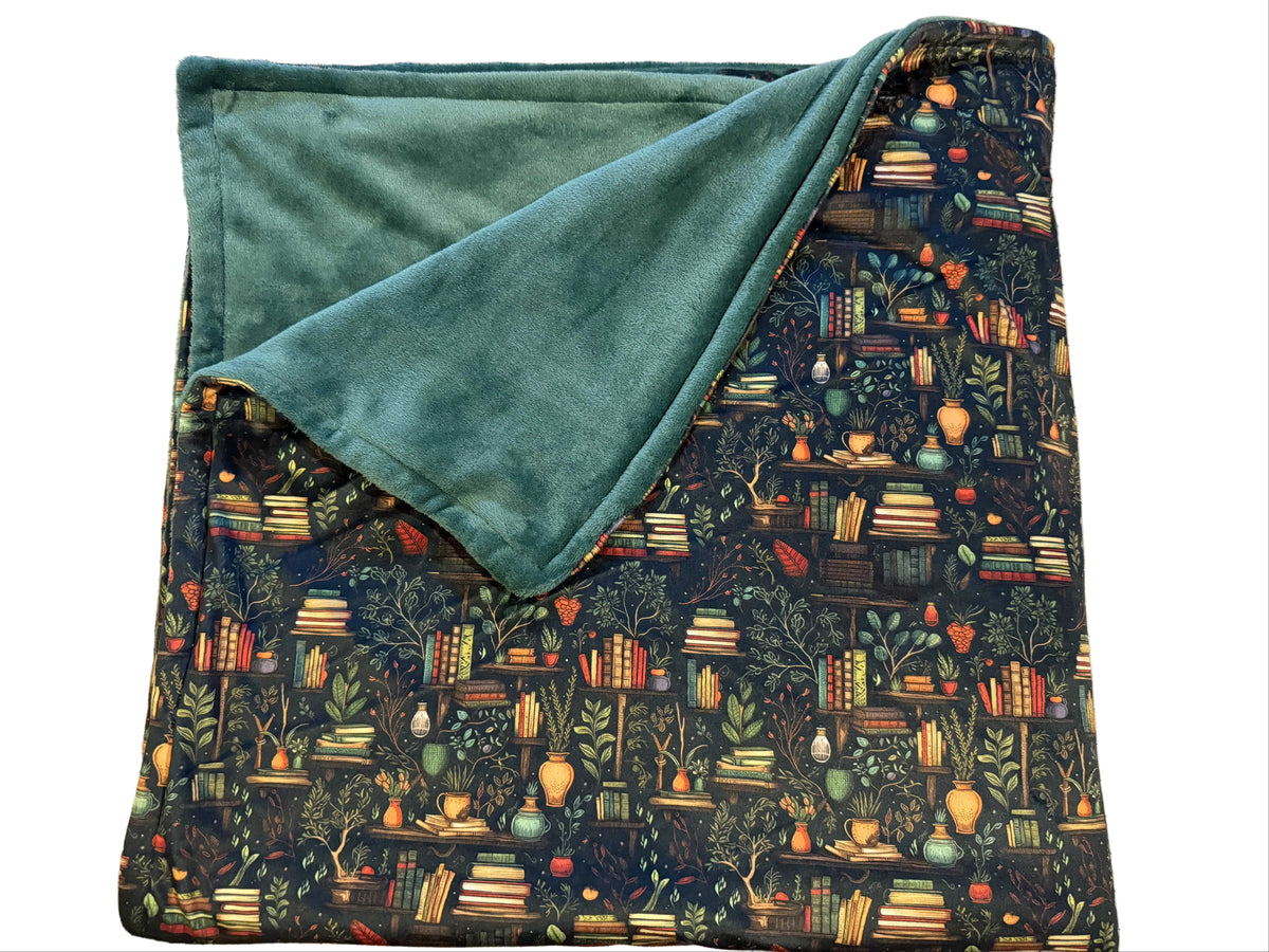 Large double-sided blanket with a whimsical books and botanicals print and sage plush reverse