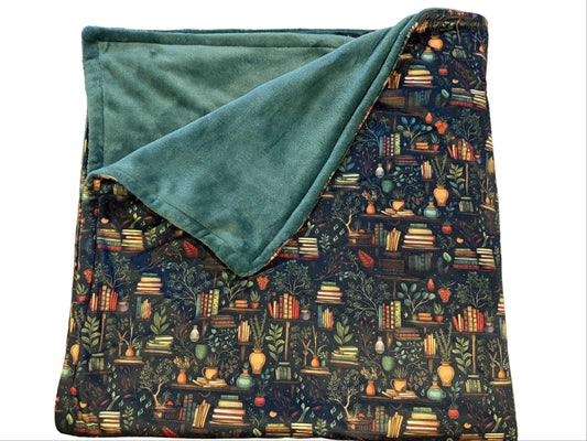 Large double-sided blanket with a whimsical books and botanicals print and sage plush reverse
